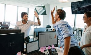 Business associates high-fiving in celebration of their improved quality outcomes